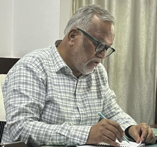 An image of the author Vasant Bhosale writing at his desk